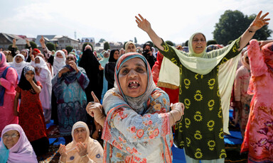 Close-up of a woman gesticulating with other women behind her