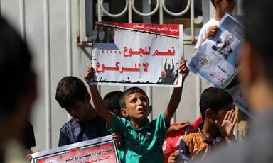 Young boys hold posters