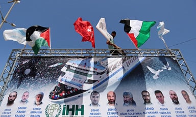 Large banner with flags, photos and names of victims