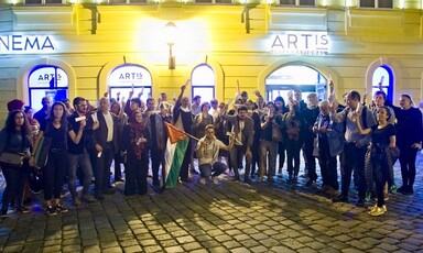 Large group of people stands in front of building