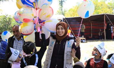  A charity worker hands out ballons to children