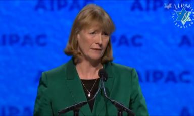 A woman speaks into a podium microphone