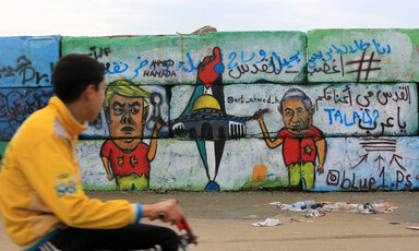 A boy looks at graffiti on a wall