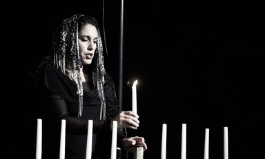 Woman lighting menorah candles 