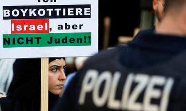 Woman holds placard as she stands beside police officer