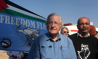 Two men stand in front of banner reading "Freedom Flotilla" 