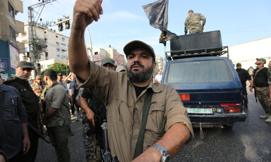 A man armed with a gun gestures