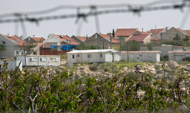 Landscape view of settlement homes with barbed wire in foreground