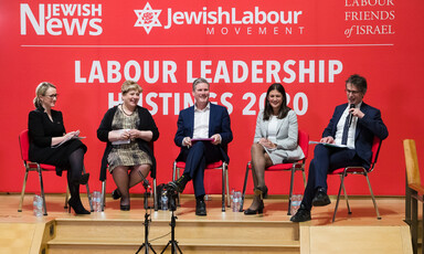 Three women and two men sit on a platform