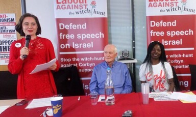 A standing woman speaks into a microphone