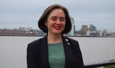 A woman stands by a riverfront