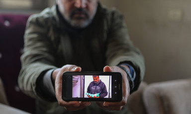 Man holds smart phone towards camera