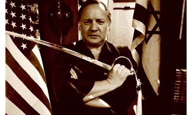 Man with sword stands with US and Israeli flags