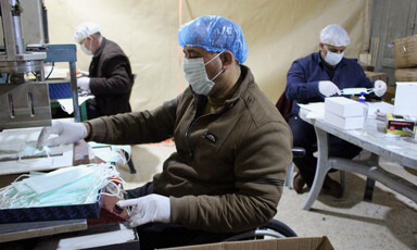 People wearing hair nets and masks at work