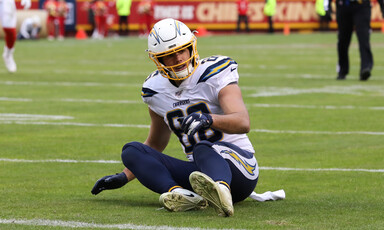 American football player sits on ground