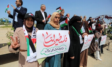 People stand with banners and flags