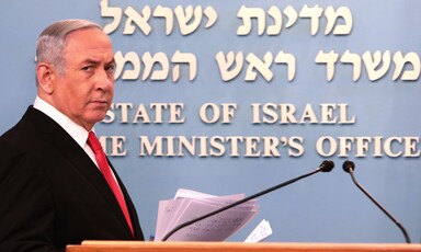 Benjamin Netanyahu stands behind podium