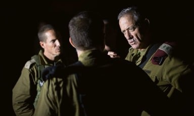 Three men in military uniforms converse