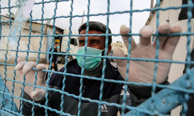 Man wearing face mask holds barbed wire