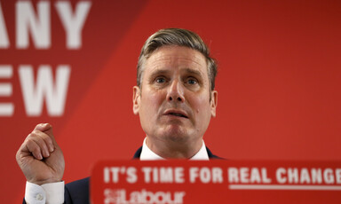 A man in a suit talks from a lectern