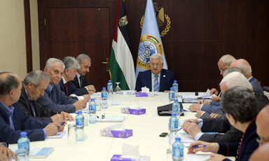 People in suits sit around a table
