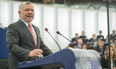 Man in suit standing before podium