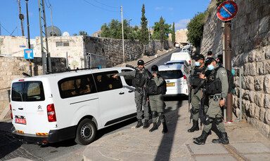 Armed soldiers in protective masks stand near vans