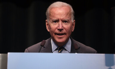 Man at podium looks straight ahead