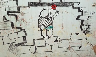 Image of boy holding a flower painted on a wall 