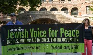 Protestors hold up a banner urging the US to end military aid to Israel