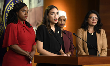 Four women stand at podium