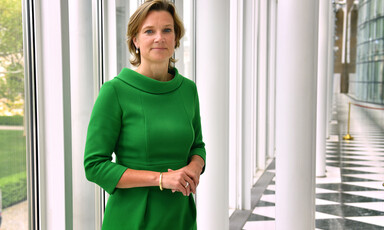 Woman stands in front of pillars 