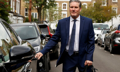 A man in a suit entering a car