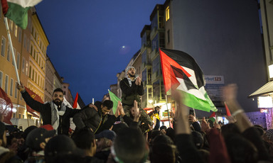 Evening protest where people wave Palestinian flags
