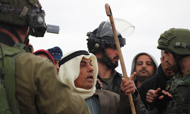 Man surrounded by soldiers gestures and speaks