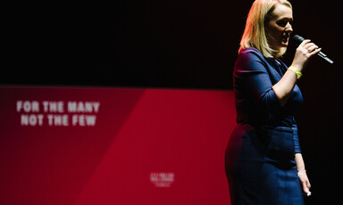 A woman in a dress speaking into a microphone