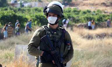 Heavily armed soldier wearing protective mask 