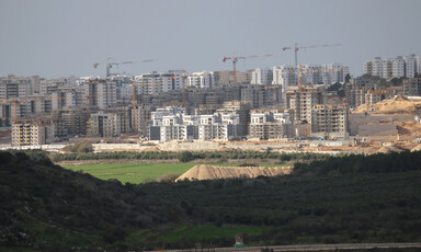 Construction cranes tower over apartment buildings