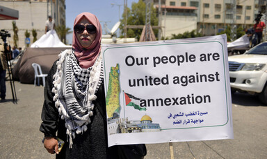 Woman in sunglasses holds sign