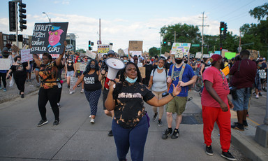 Woman with megaphone leads marching protesters