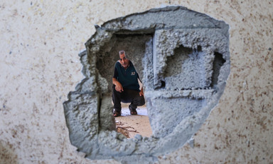 Man looks through hole in wall