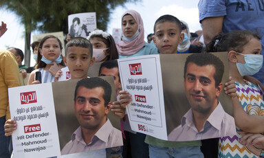 Children and adults hold signs