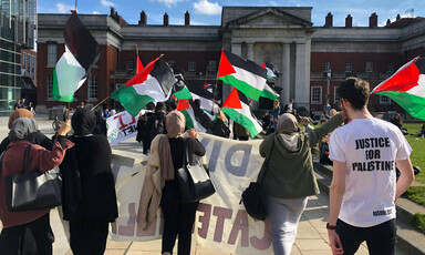 People carry flags and protest signs