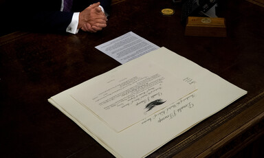 A document lies on a wooden desk