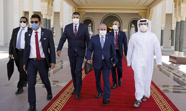 Men in protective masks walk out of building 