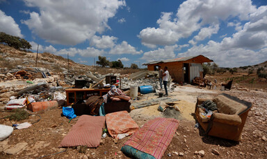 Damaged furniture and rubble on open land 