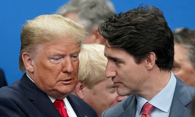 Two men in suits talk to each other.