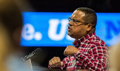 Man makes fists while speaking at podium