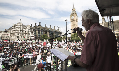 Man speaks into a microphone in front of crowd