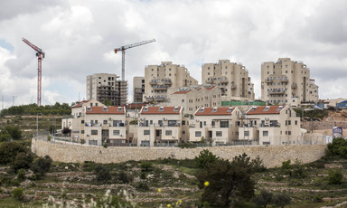 Landscape view of Israeli settlement and construction cranes